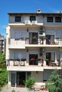 een gebouw met tafels en stoelen op de balkons bij Vila Delfin in Ohrid