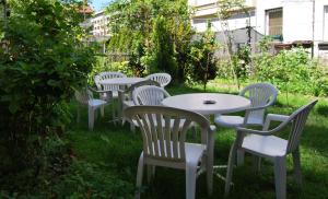 een rij witte tafels en stoelen in het gras bij Vila Delfin in Ohrid