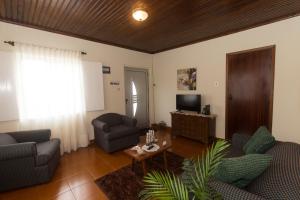 uma sala de estar com dois sofás e uma televisão em Casa do Galante em Porto Judeu