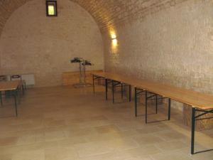 Habitación con mesas, sillas y pared de ladrillo. en B&B Masseria Spilafemine, en Turi