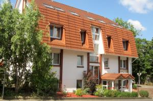 een groot wit gebouw met een oranje dak bij Arador-City Hotel in Bad Oeynhausen