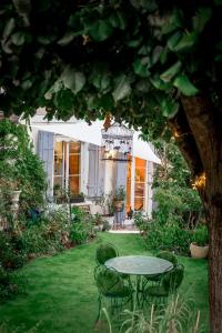 een patio met een tafel en stoelen in een tuin bij La Maison Charmante in Châtellerault