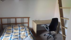 a bedroom with a desk and a chair next to a bed at Rooms in the apartment-center in Košice