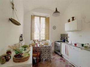 una cocina con encimera y mesa. en Castello di Grotti, en Corsano