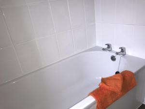 a white bath tub with a red towel on it at The Avenues in Chelmsford