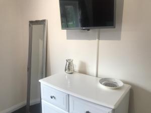 a white cabinet with a tv on the wall at The Avenues in Chelmsford