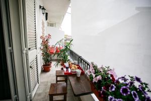 a balcony with a wooden table and flowers on it at B&B Scirocco House in Oliveri
