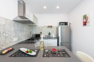 a kitchen with a counter top and a refrigerator at Apartment Mirella 1 "Your sunny sea-view escape with two terraces in the heart of Rabac" in Rabac +14 photos
