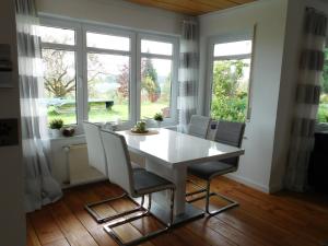 a dining room with a table and chairs and windows at Ferienwohnung Elsbeere in Blankenheim