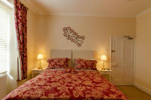 um quarto com uma cama vermelha e 2 candeeiros em Pinfold House em Richmond