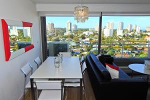 comedor con mesa blanca y sillas en Alexander Boulevard, en Punta del Este