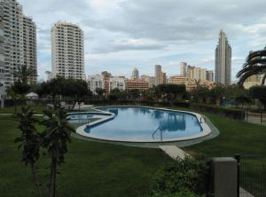 a swimming pool in a park with a city in the background at Mediterranean Bliss 317 in Cala de Finestrat