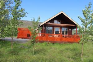 una casa con una recinzione arancione in un campo di Hrísmóar a Reykholt