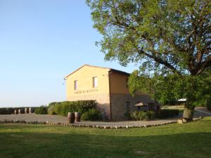 TerricciolaにあるAgriturismo Pieve de Pittiの畑の前に木が立つ建物