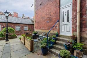 a courtyard with potted plants on a brick building at Beach Hideaway in Lytham St Annes