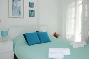 Una cama con almohadas azules y toallas. en La Playa Blanca 4, Duquesa, Beach, Sea View, Pool, WiFi, en Torrevieja