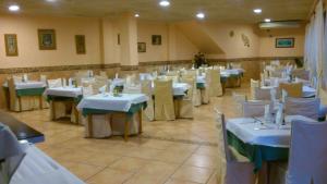 a dining room with white tables and white chairs at Hotel Paloma in San Pedro del Pinatar