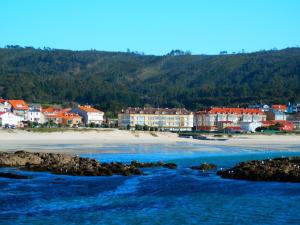 a beach with a group of buildings and the ocean at Apartamento en Sardiñeiro in Sardiñeiro de Abajo