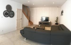 a living room with a black couch and a tv at Ma Ré Haute in La Flotte