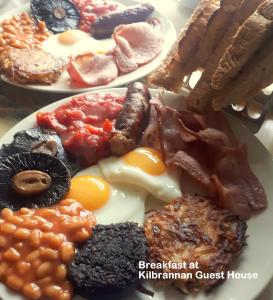 Dois pratos de pequeno-almoço com ovos, feijão e bacon em Kilbrannan Guest House em Great Yarmouth