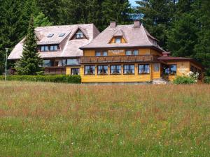 ein großes Holzhaus inmitten eines Feldes in der Unterkunft Hotel Restaurant Peterle in Feldberg