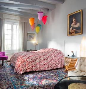 a bedroom with a large bed with a red bedspread at La Maison Charmante in Châtellerault