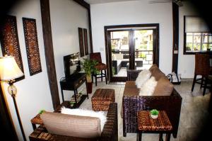 a living room with a couch and chairs and a piano at Caribbean Beach Cabanas in Placencia Village