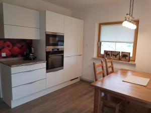 a kitchen with white cabinets and a wooden table at Appartment LuKi in Haus im Ennstal