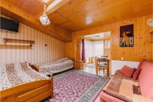 a room with two beds and a couch and a tv at Wędrowiec in Karwia