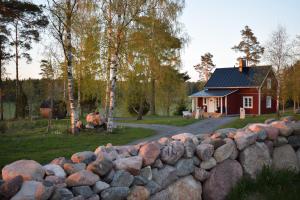 a stone fence in front of a small house at Countryside Villa Skogsbacka in Tammisaari