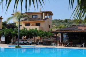 a large blue swimming pool in front of a building at Villa Eugenia in Theológos