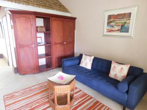 a living room with a blue couch and a table at La Haut Resort in Soufrière