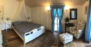 um quarto com uma cama grande e uma cadeira em Penzion Primášé em Dolní Věstonice