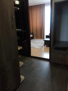 var-ketili في تبليسي: غرفة مع مرآة وغرفة معيشة مع تلفزيون