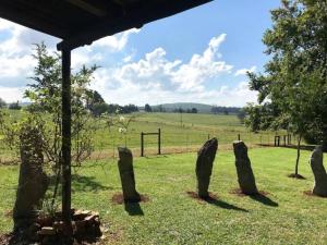 a group of stones in a field with a fence at 180 at Mission House in Curryʼs Post