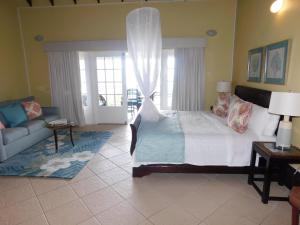 a bedroom with a bed and a living room with a couch at La Haut Resort in Soufrière