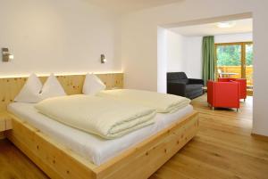 - une chambre avec un grand lit et un cadre en bois dans l'établissement Berghotel Lämmerhof, à Sankt Martin am Tennengebirge