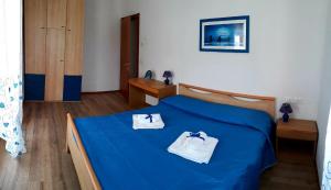 a bedroom with a blue bed with two towels on it at Mariel Holiday Home in Levico Terme