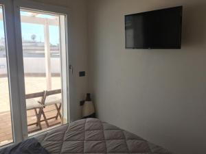 a bedroom with a bed and a television on the wall at Attico vista mare in Su Forti