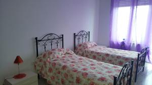 a bedroom with two beds and a window at Appartamento da Maria Francesca in Matera