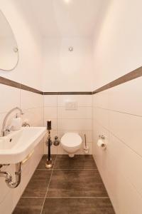 a white bathroom with a sink and a toilet at Alte Brauerei in Bernkastel-Kues