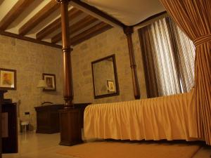 a bedroom with a bed with a canopy and a table at Señorio de Olmillos in Olmillos de Sasamón