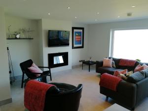 sala de estar con 2 sofás y chimenea en Links Vista Portrush, en Portrush