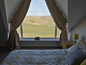 a bedroom with a bed and a window with a view at Links Vista Portrush in Portrush
