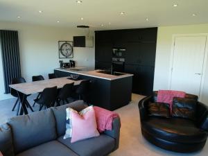 a living room with a couch and a kitchen at Links Vista Portrush in Portrush