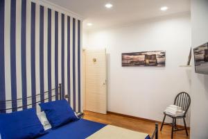 ein Schlafzimmer mit einem blauen Bett und einem Stuhl in der Unterkunft Petrucci B&B in Neapel