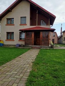 a house with a brick path in front of it at Vila de vacanta Curtea de Arges in Curtea de Argeş