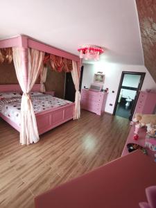 a bedroom with a pink bed with a canopy at Vila de vacanta Curtea de Arges in Curtea de Argeş