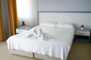 a white bed with white sheets and pillows on it at Aloria Garden Hotel in Erdek