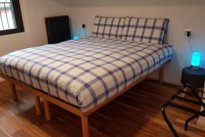 een bed in een kamer met een geruite deken erop bij La casa degli ulivi in Lierna